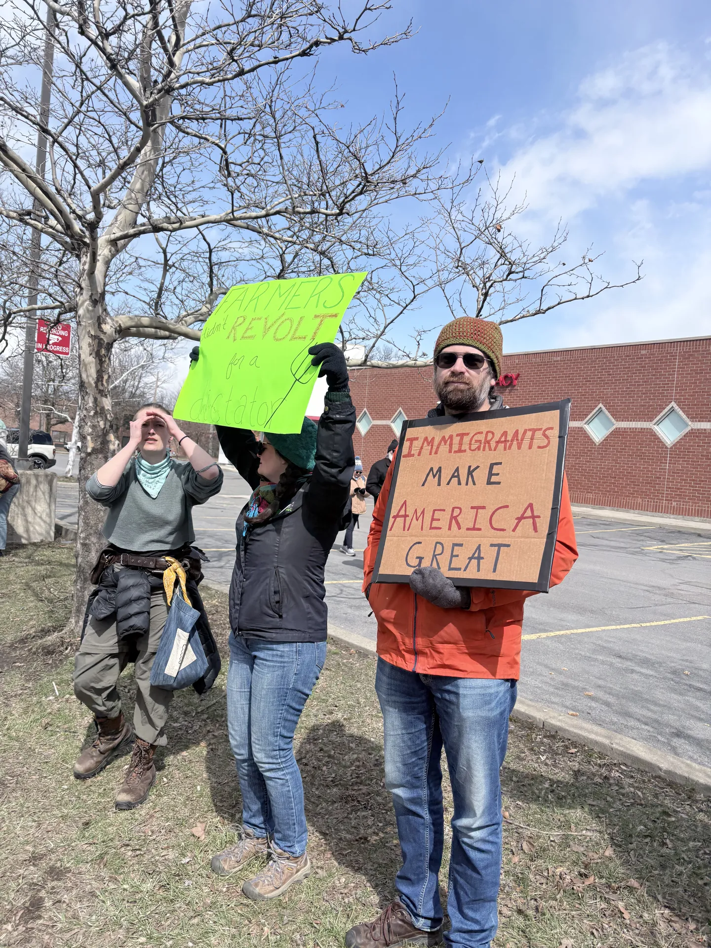 Participants at a public demonstration holding immigrant solidarity signs